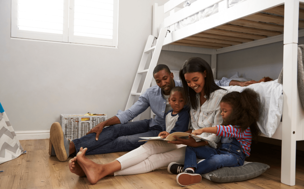 Parents and 2 Children Reading in Bedroom