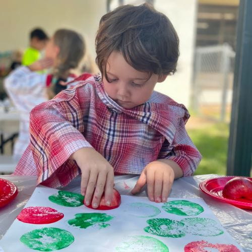 Child Painting with Apples