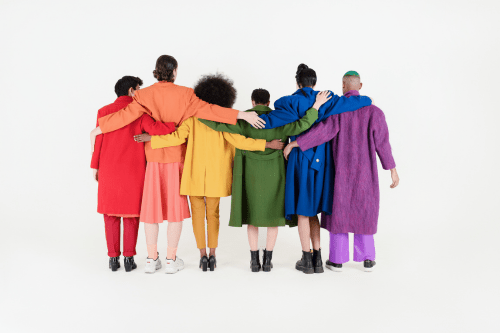 Group of people wearing a range of colored coats like a rainbow