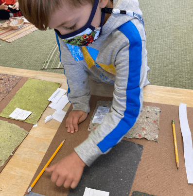 Child flattens wet paper onto flat surface